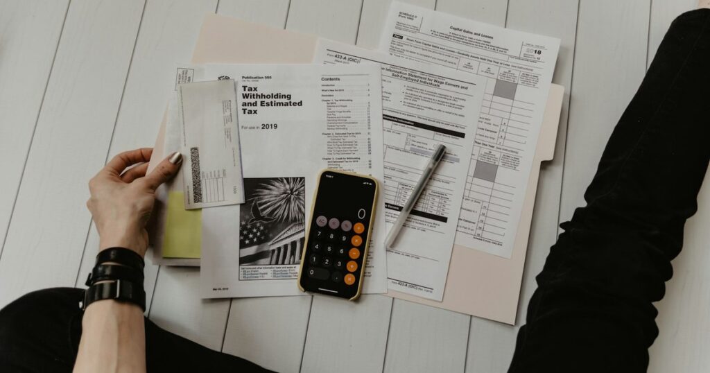 Moduli fiscali, calcolatrice e penna sulla scrivania